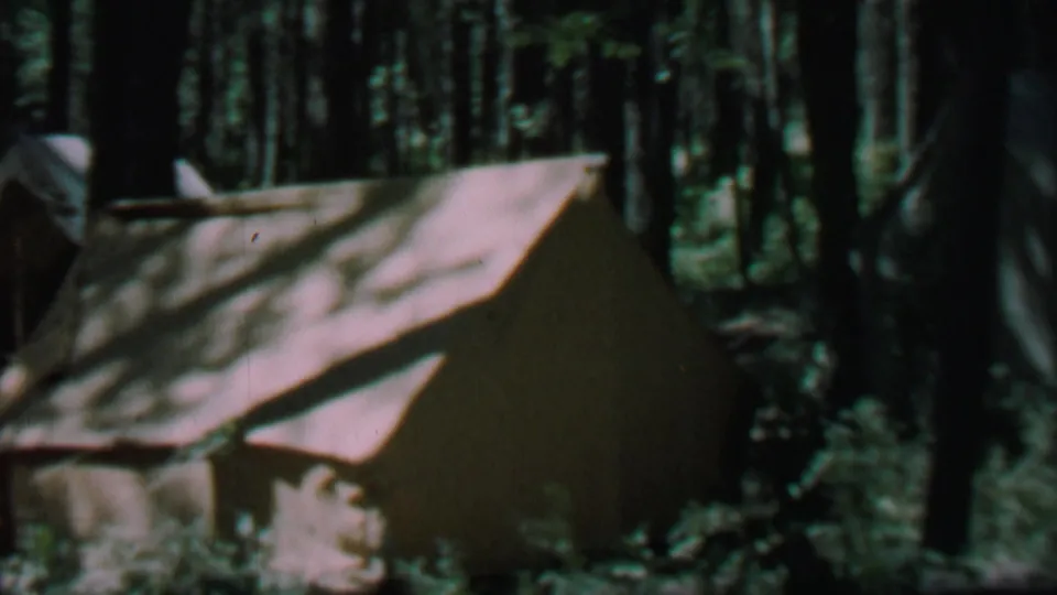 Close view of a canvas tent in the Farragut State Park forest campsite, filmed in 1967 on 8mm home-movie stock.
