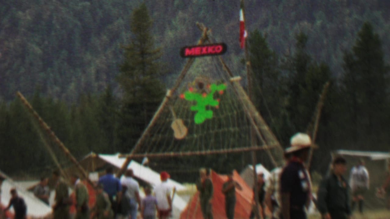 1967 Farragut State Park festival scene with a Mexico sign, cactus decoration, Mexican flag, tents, and visitors crossing a grassy field.