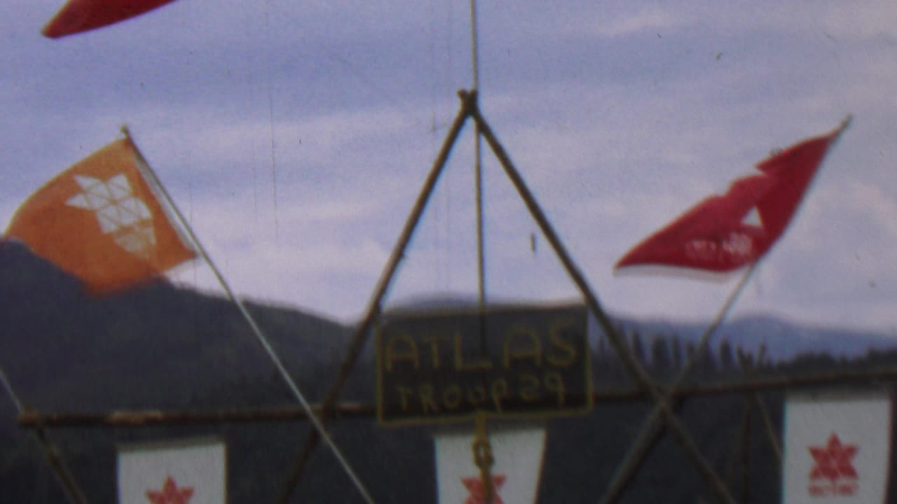 1967 Farragut State Park footage shows red and orange flags around a wooden tripod structure with a hand-painted Atlas Troop 29 sign and forested hills behind it.