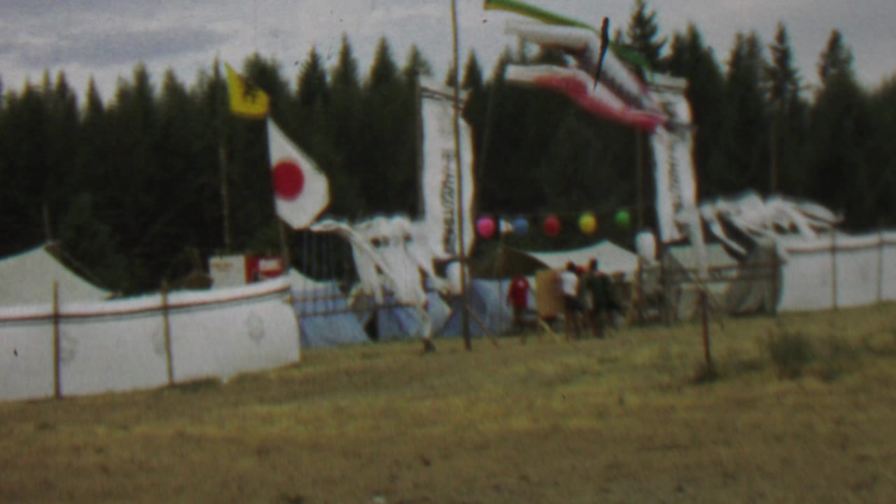 Decorated outdoor entrance with Japanese flag, banners, carp streamers, balloons, and people nearby.