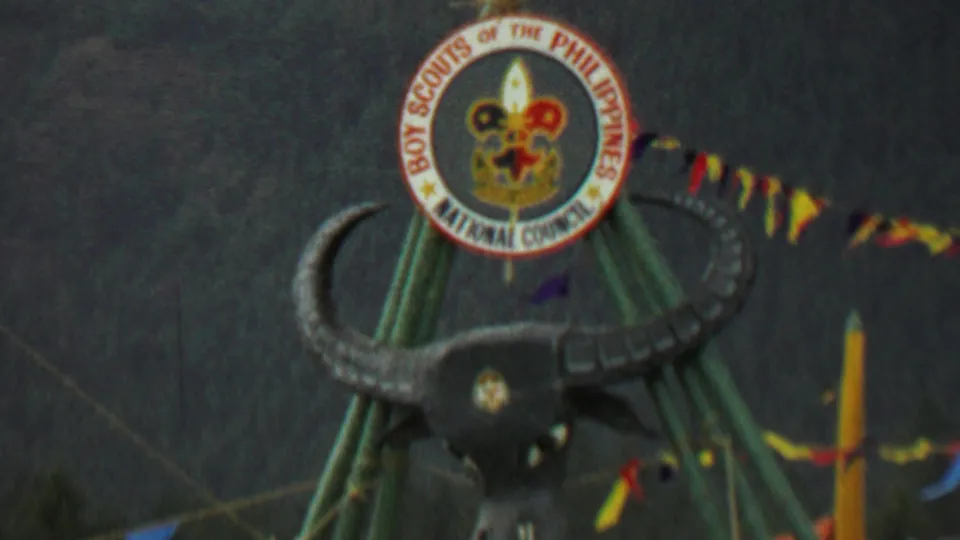 Close 1967 Farragut State Park frame showing the circular Boy Scouts of the Philippines National Council emblem above a stylized bull's head on green poles, with pennant flags crossing the background.