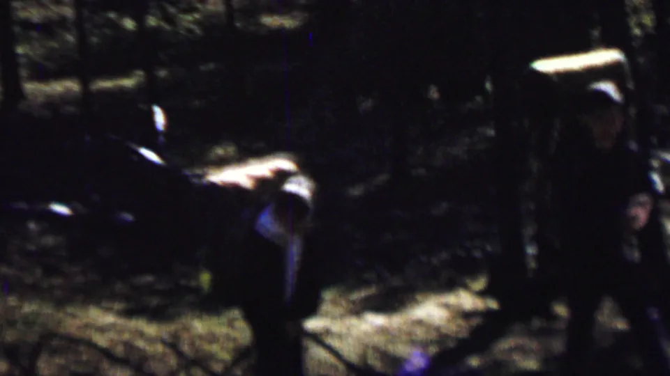 A backpacker appears in profile or partial silhouette in the wooded Farragut State Park home-movie footage, with a large pack visible against the dark trees.