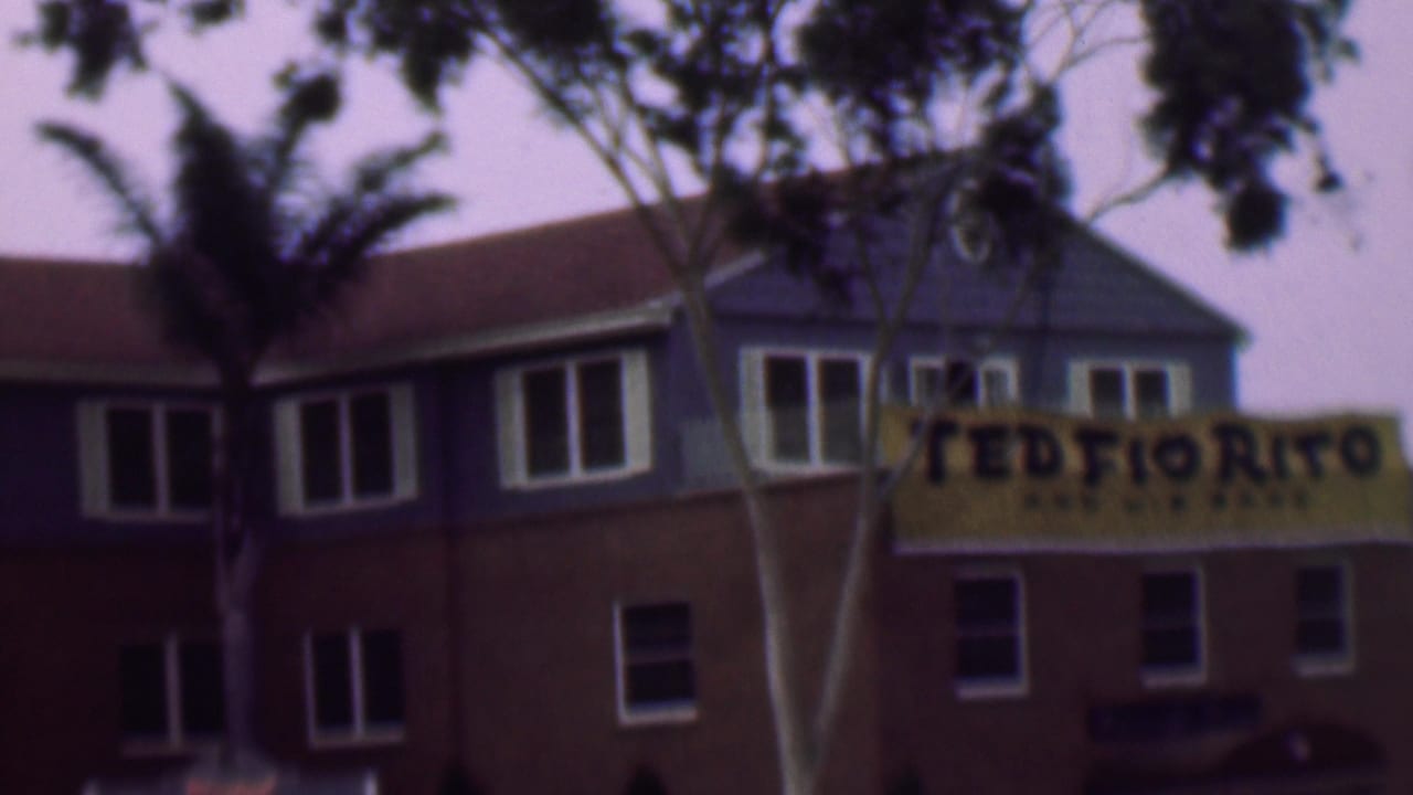 Yellow Ted Fio Rito banner on the right side of a two-level building behind trees.