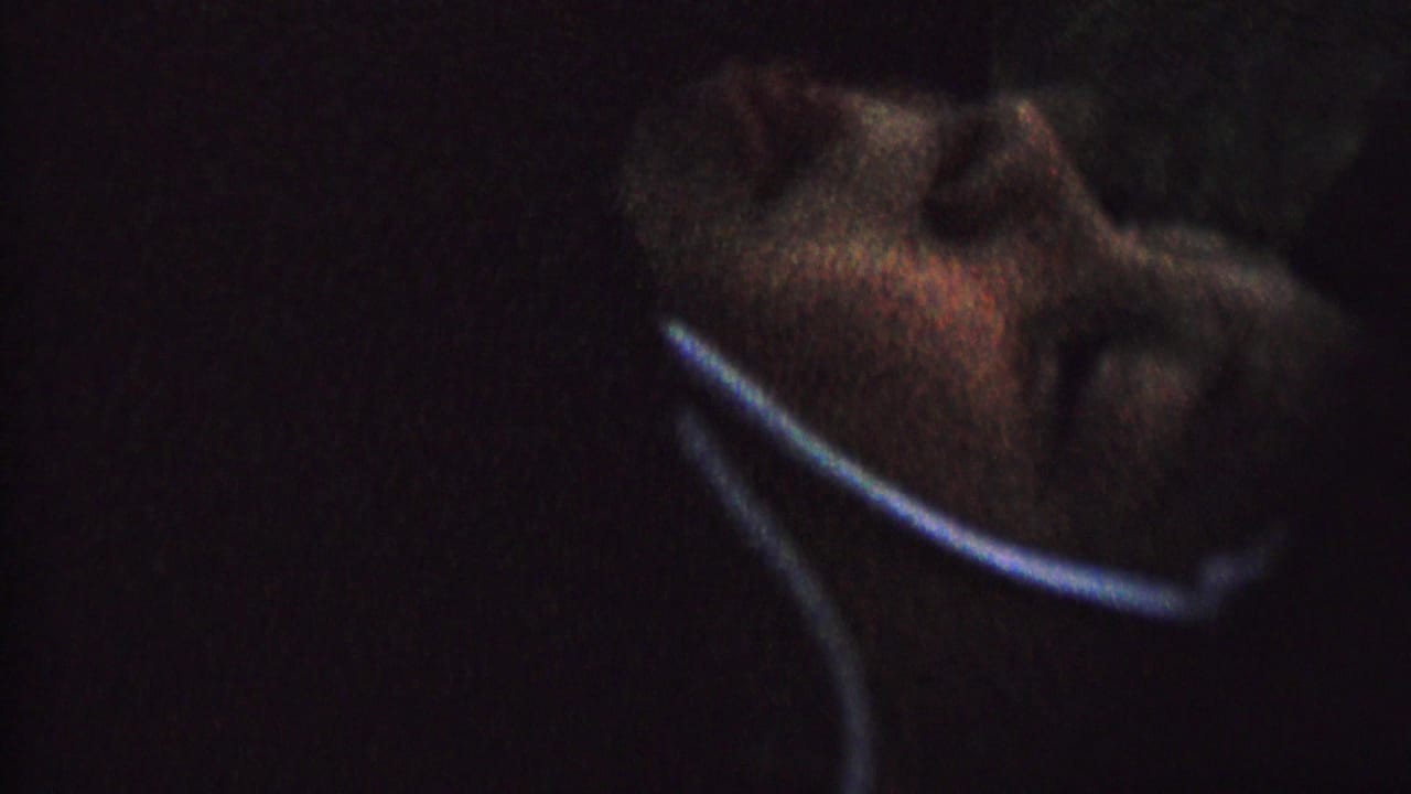 A partial face and collar-like edge appear in shadow within dark 1962 8mm home-movie footage from the supplied St. Paul, Minnesota metadata.