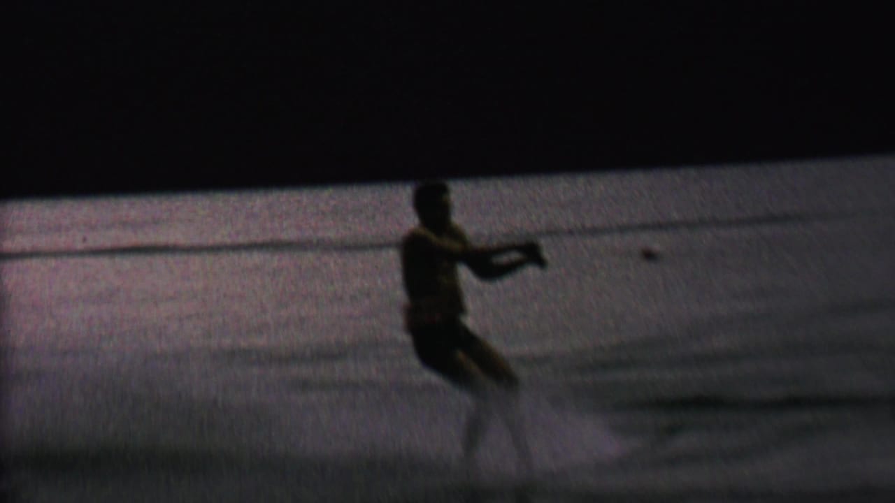 Water skier holding a tow rope as he moves across the lake.