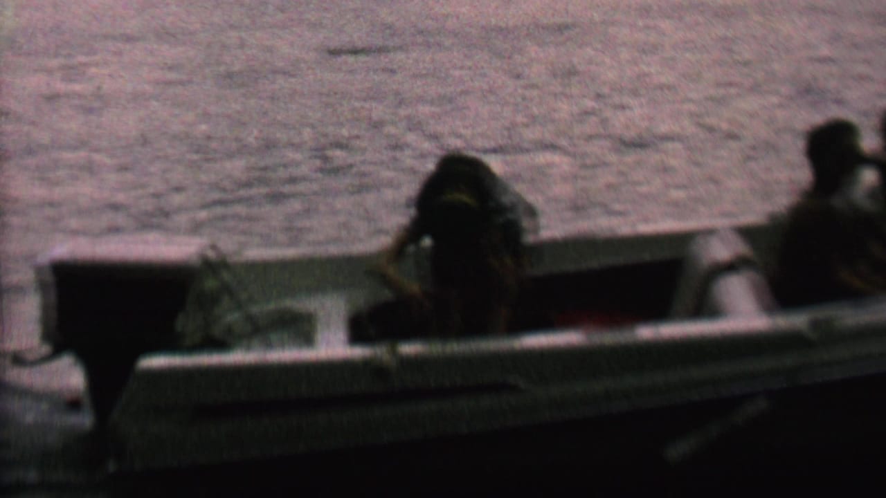 Two small boats or boat sections appear on dark water with passengers seated and leaning inside.
