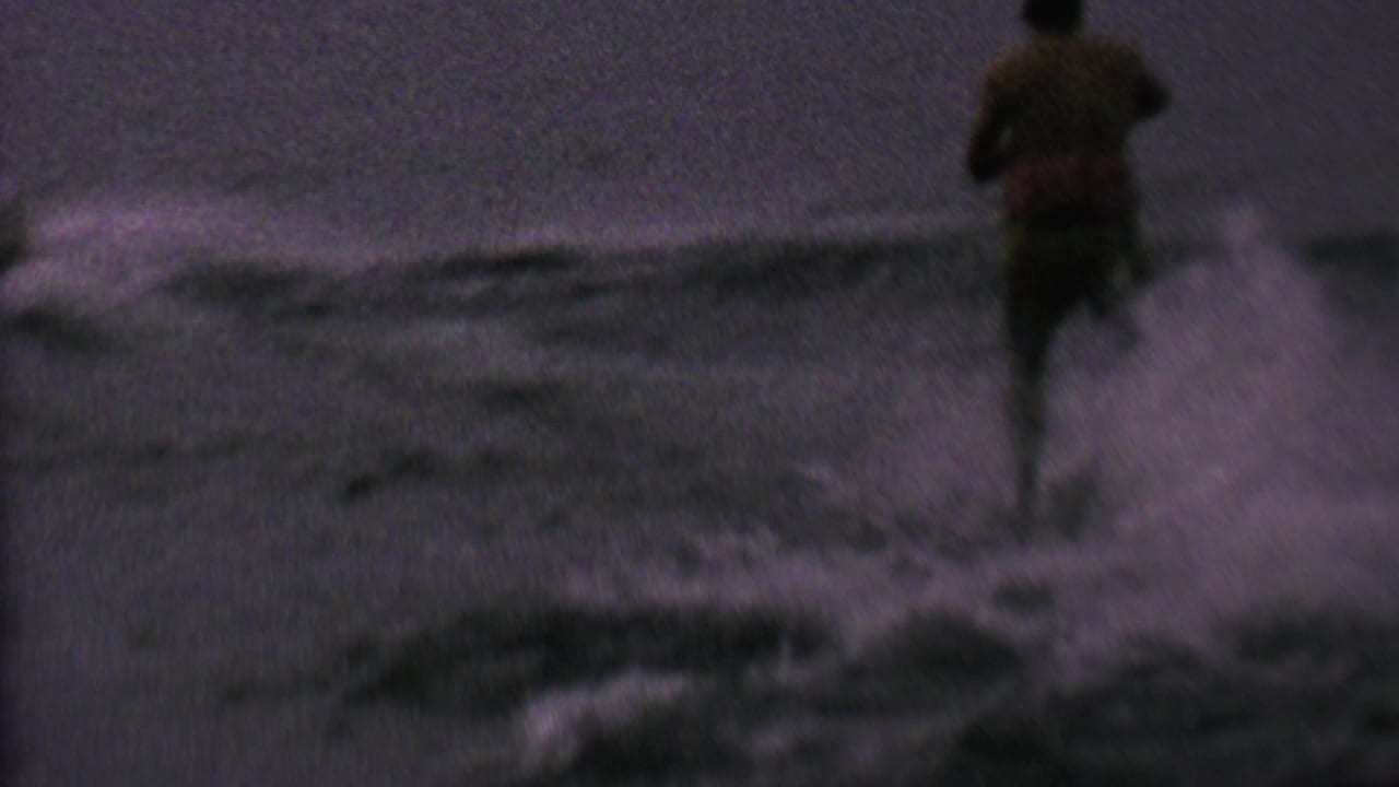 A distant waterskier appears on a lake in archival 8mm footage from the supplied 1962 St. Paul, Minnesota metadata, with wake and spray surrounding the skier.