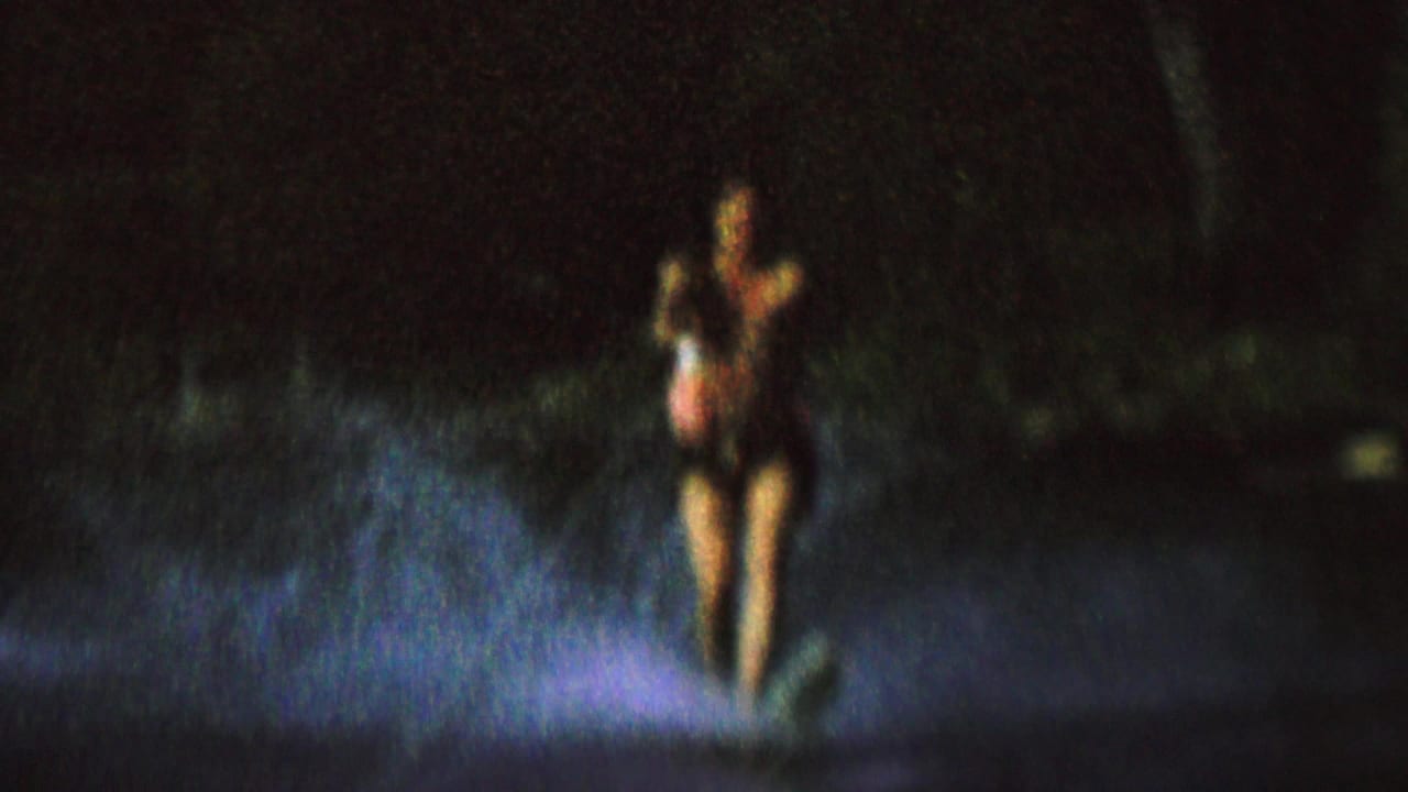 In 1962 home-movie footage from the supplied St. Paul, Minnesota metadata, a woman appears water skiing at night across a dark lake under a strong boat-side light.