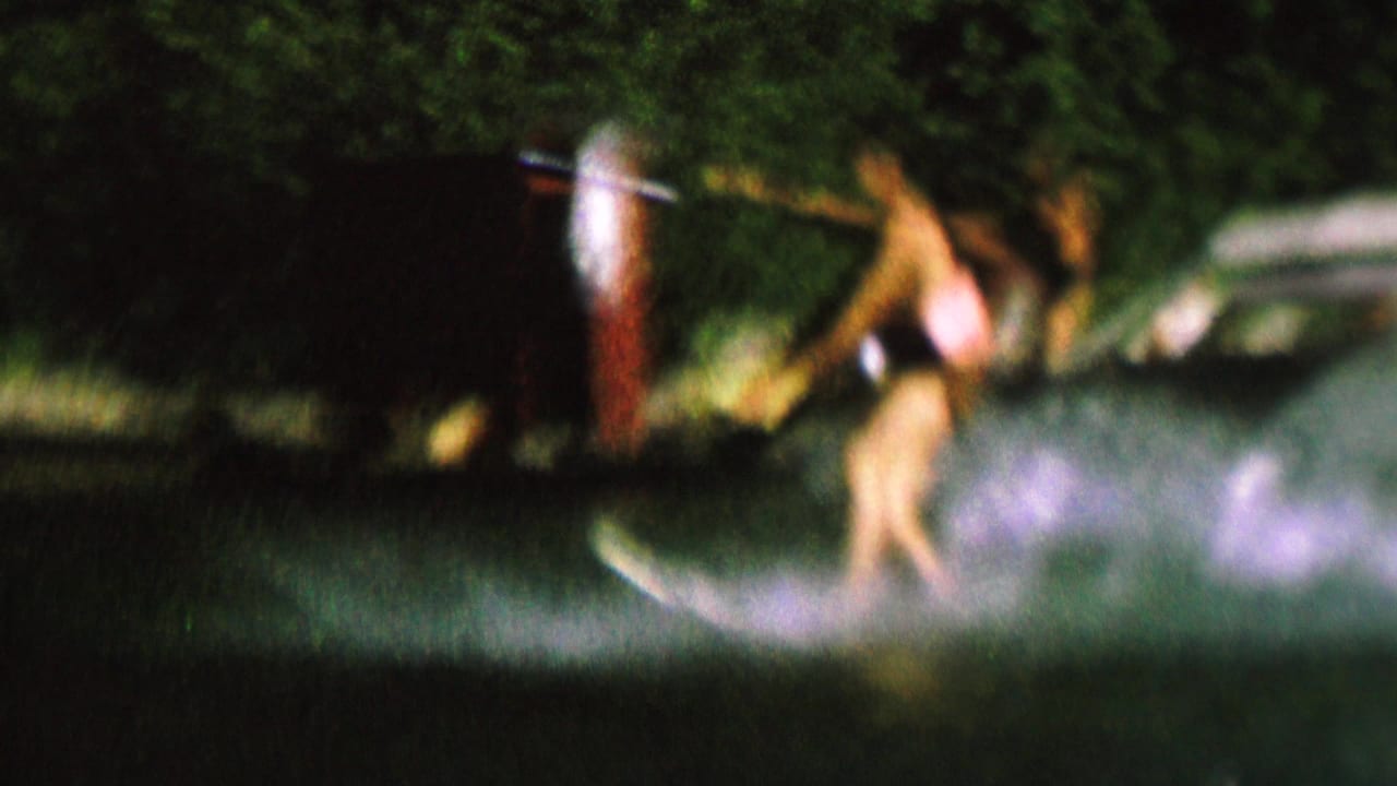 A water skier leans across choppy lake water while holding a tow rope.