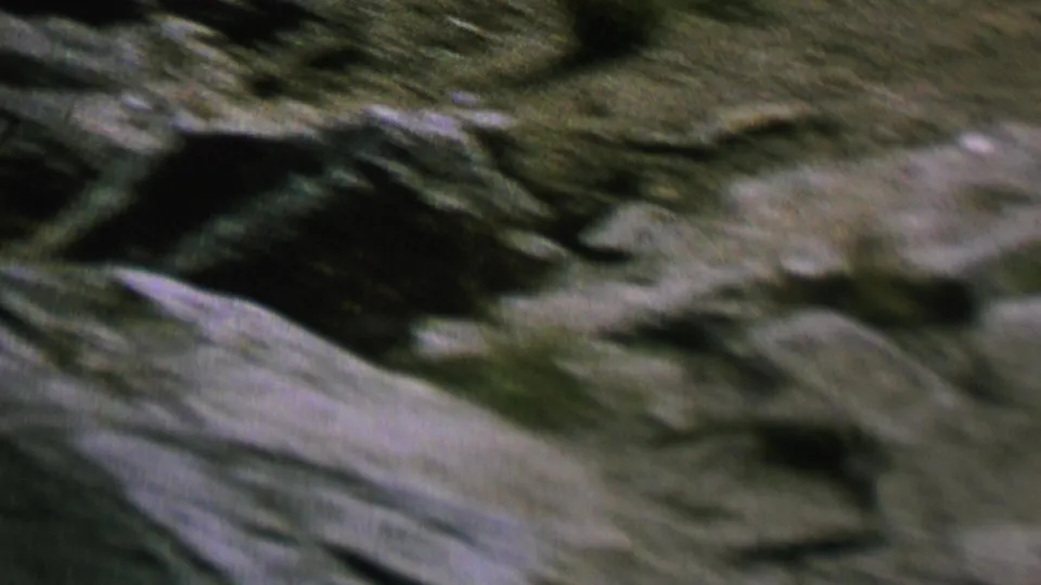 1962 St. Paul 8mm frame with blurred pale and dark rock surfaces filling the view under dim exposure.