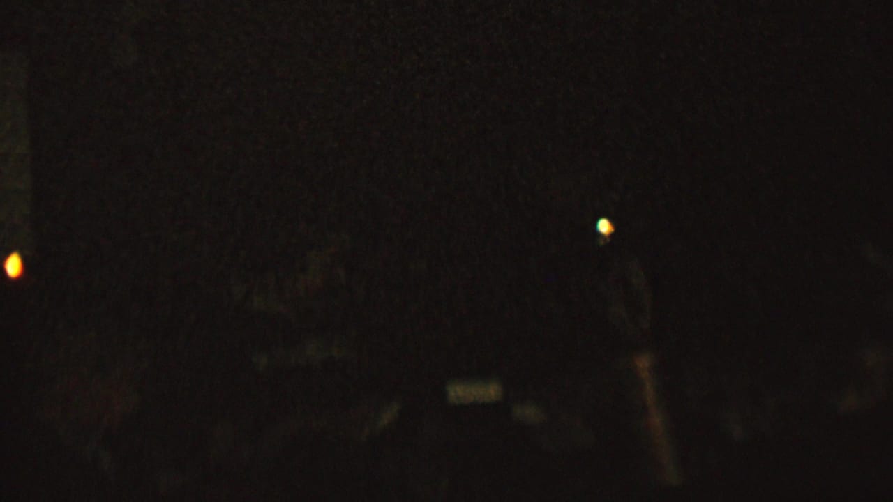 Very dark 1962 8mm home-movie frame from the supplied St. Paul, Minnesota metadata, showing scattered candlelike light points and barely visible interior shapes.