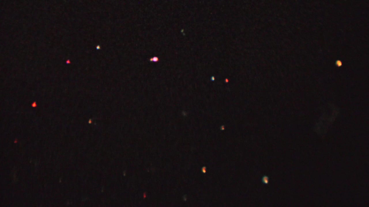 1962 8mm home-movie frame from St. Paul, Minnesota showing a very dark skyline with scattered colored lights and indistinct foreground silhouettes.