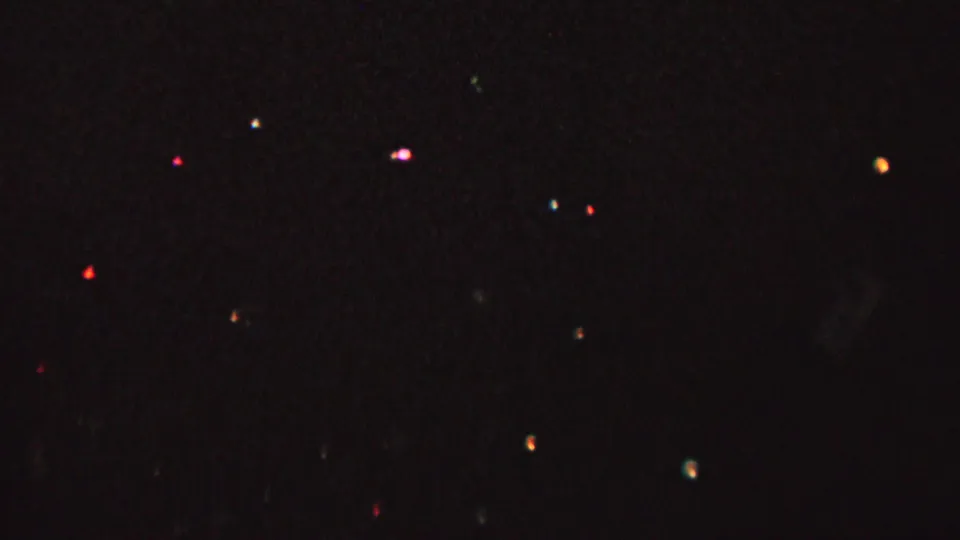 1962 8mm home-movie frame from St. Paul, Minnesota showing a very dark skyline with scattered colored lights and indistinct foreground silhouettes.