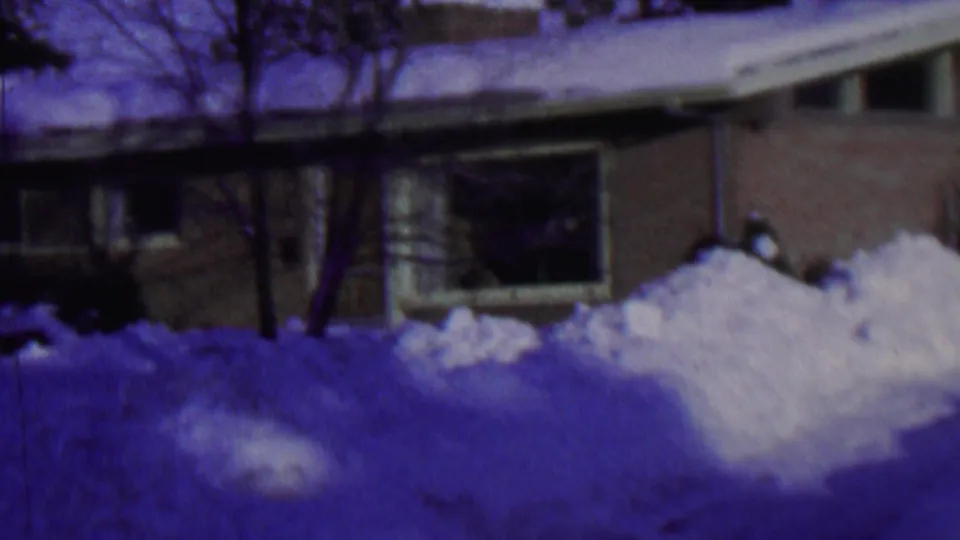 1962 St. Paul, Minnesota home-movie frame with the house roof and front windows more visible above high winter snowbanks.