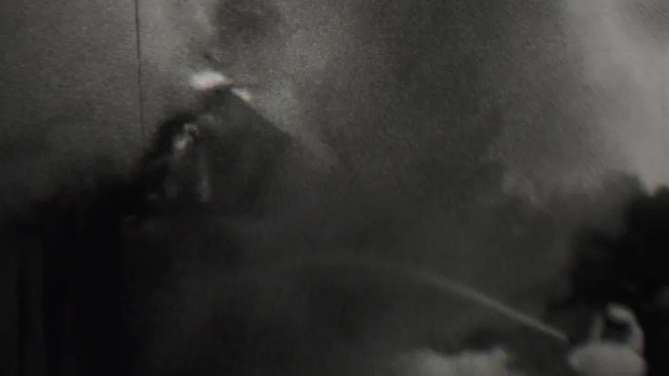 In supplied 1937 Trenton, New Jersey home-movie footage, smoke billows near a dark structure while a hose stream cuts across the scene.