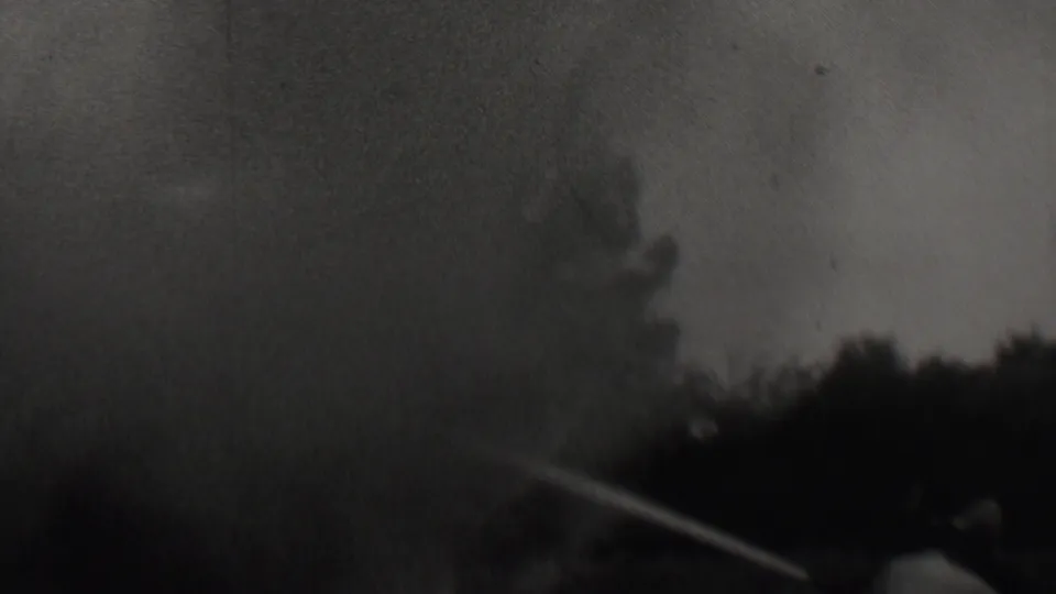 Dense smoke spreads across the scene in the 1937 Trenton fire footage, with a hose stream directed upward from the lower left.