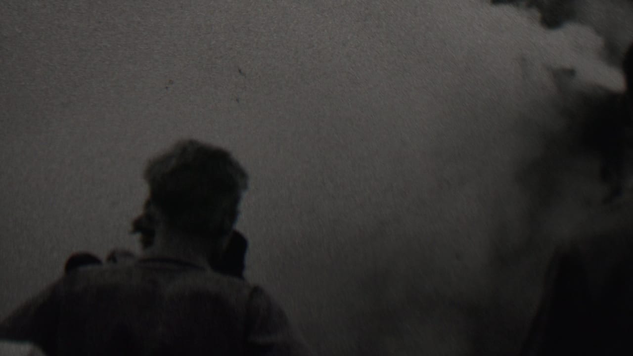 In 1937 Trenton, New Jersey metadata, silhouetted men stand with their backs to the camera while dense smoke or fumes spread across the frame.