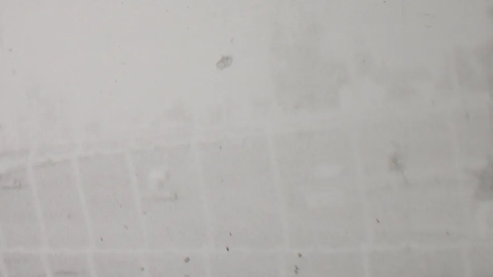 Soft, overexposed 8mm frame from the supplied 1937 Trenton racing clip, showing faint trackside forms and fence lines with little distinct detail.