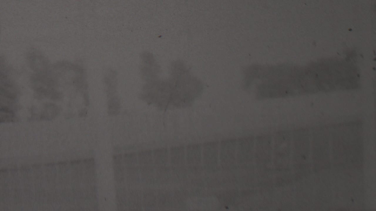 Very dark 1937 8mm home-movie frame from the described Trenton, New Jersey clip, showing an indistinct outdoor dirt-track area with faint trees or structures in the distance.
