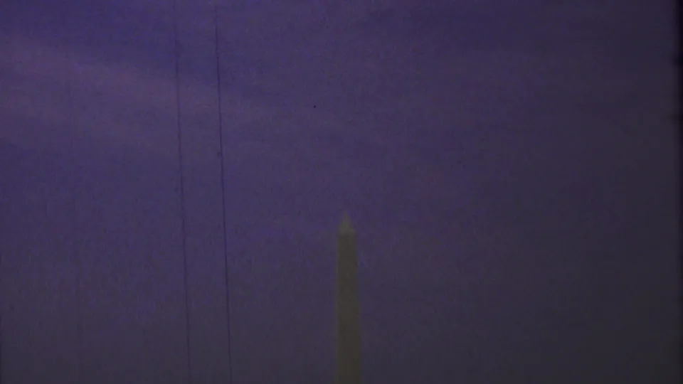 A distant view appears to show the Washington Monument as an obelisk silhouette against a purple-hued sky in faded 8mm color.