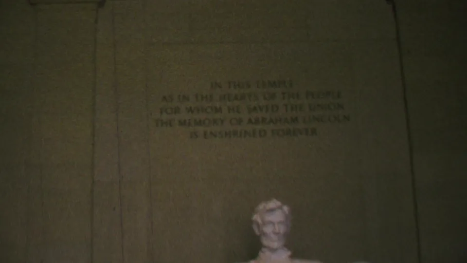 1969 8mm frame inside the Lincoln Memorial, showing the carved inscription above the visible head of the Abraham Lincoln statue.