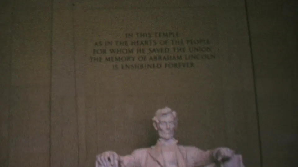 1969 Washington, D.C. home-movie frame showing more of the seated Abraham Lincoln statue beneath the Lincoln Memorial inscription.