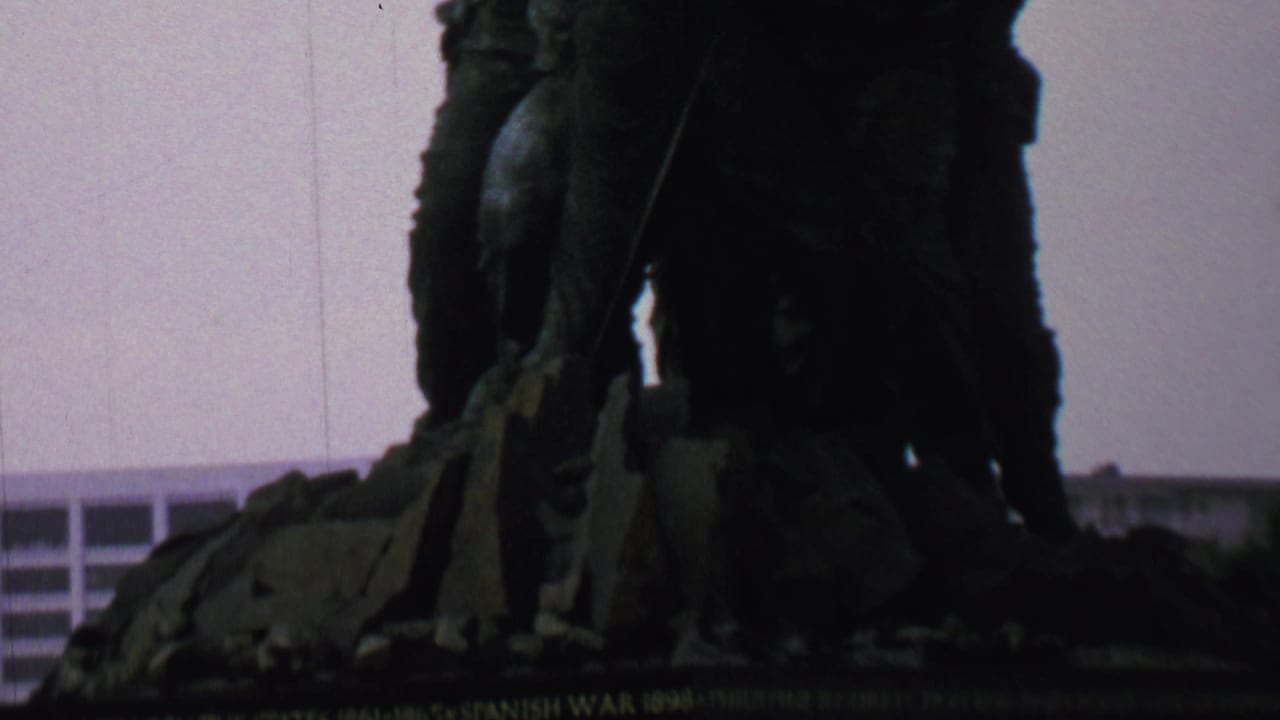 Close view of the Iwo Jima Memorial sculpture silhouetted against a pale sky.