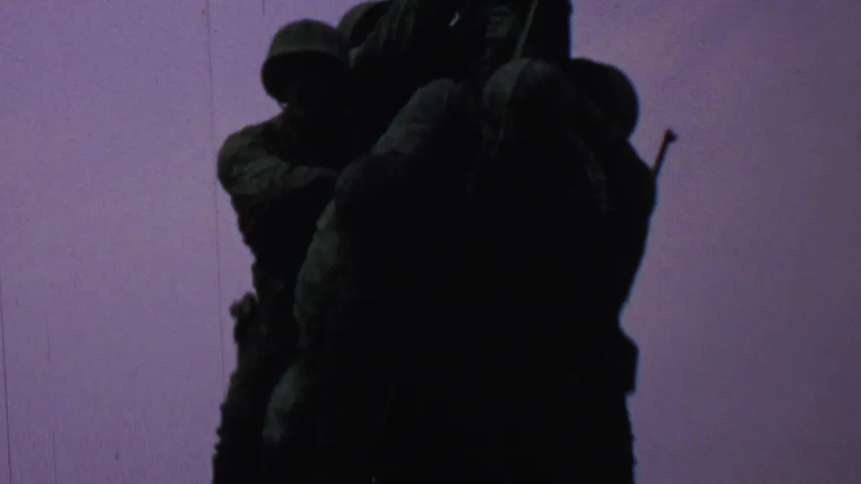 The final frame holds on the shadowed bronze figures of the Iwo Jima Memorial against a lavender-tinted sky, with the handheld 8mm framing cropping the sculpture closely.
