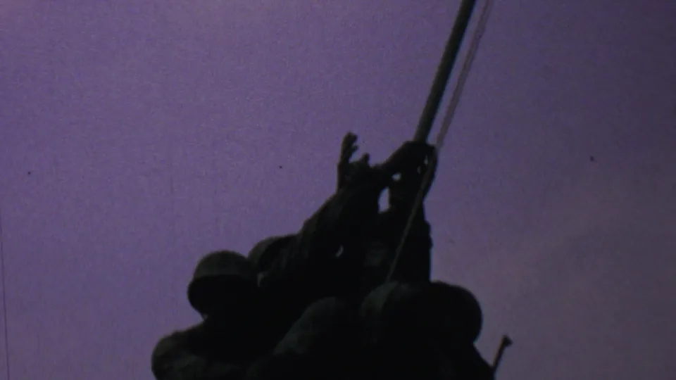 1969 Washington, DC frame showing the Iwo Jima Memorial figures grouped tightly in silhouette, with the flagpole extending upward through the sky.