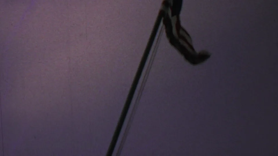 Late frame from the 1969 Washington, DC home movie showing a partial Iwo Jima Memorial figure and raised flagpole silhouetted against a dim purple sky.