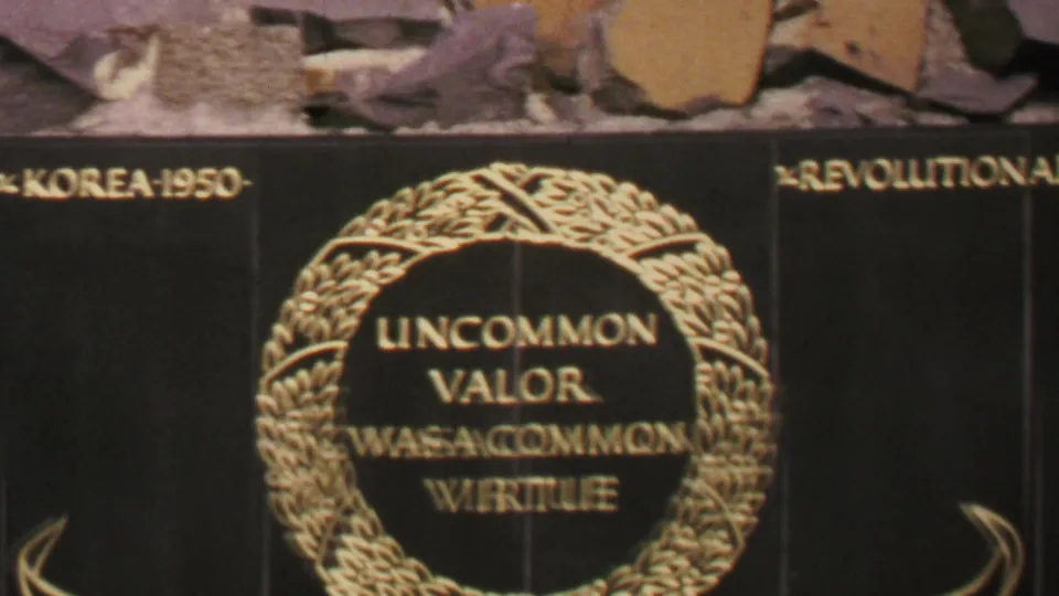 1969 Washington, DC frame showing the memorial base with a gold wreath inscription, partial “KOREA-1950” lettering, and surrounding stone panels.