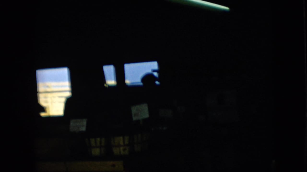 Shadowed room with glowing windows and a dark person silhouette near the upper right.