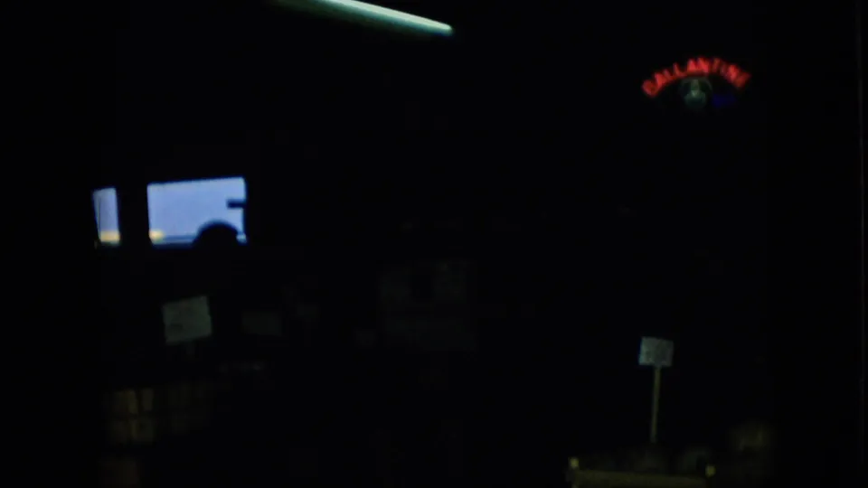 Pennsylvania 1957 8mm frame showing a shadowed interior with glowing blue window shapes, scattered small signs, and a faint red-blue sign in the darkness.