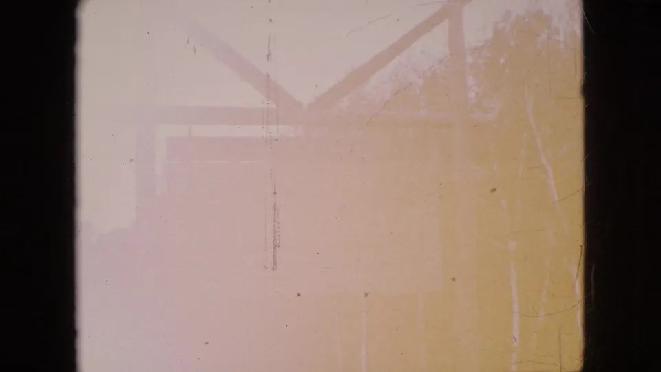 An overexposed 1964 8mm frame appears to show a rustic wooden sign structure or support near trees, with heavy light wash and film scratches.