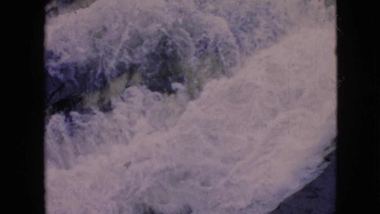 1964 8mm Niagara Falls, New York home-movie frame showing churning white water and dark blue-green river channels with visible film grain.