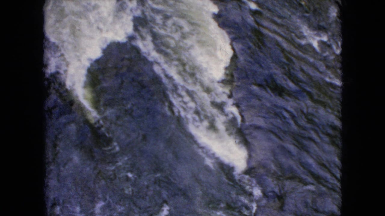 A close handheld view shows foaming water and dark exposed rocks at Niagara Falls, consistent with the supplied 1964 location metadata.