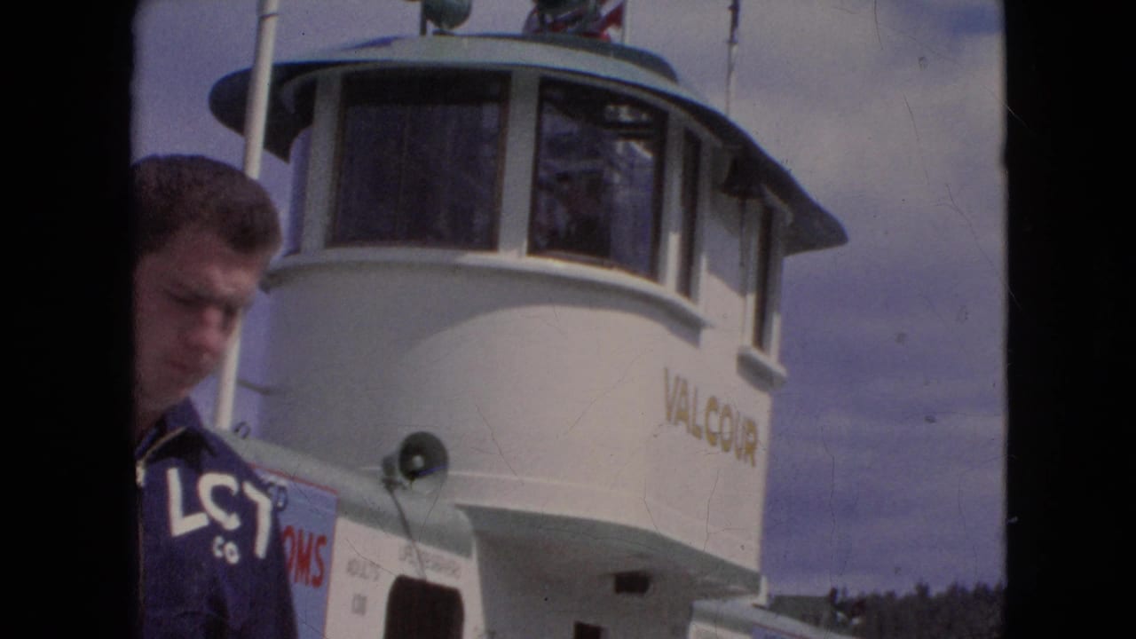Man partly framed beside the Valcour ferry pilothouse and deck equipment.