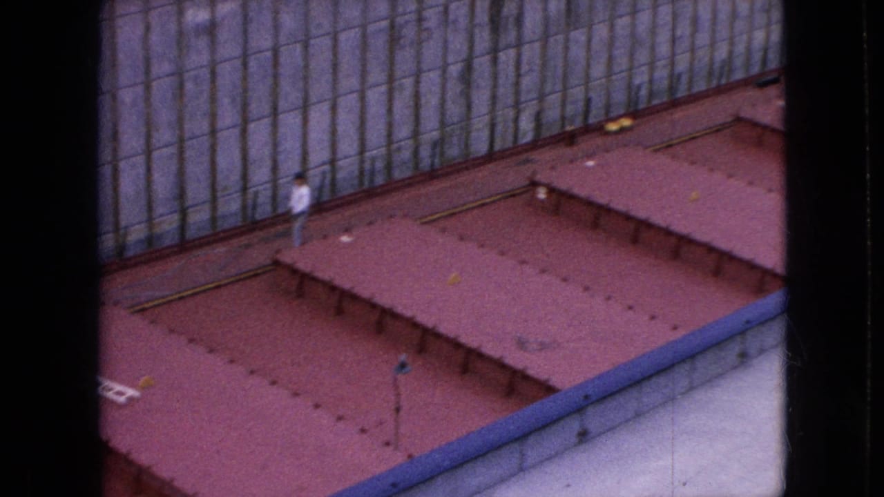 Worker walking on red cargo hatches beside a canal wall.