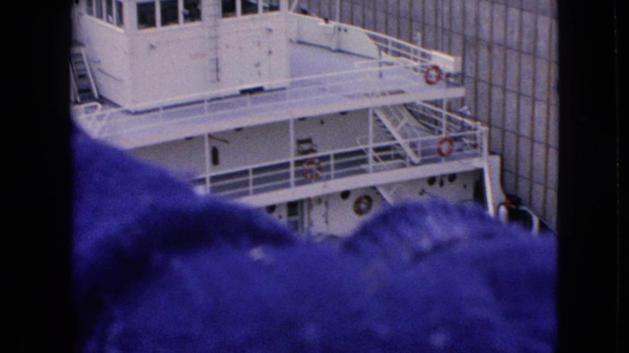 Tugboat pilothouse partly blocked by a dark foreground figure or obstruction.