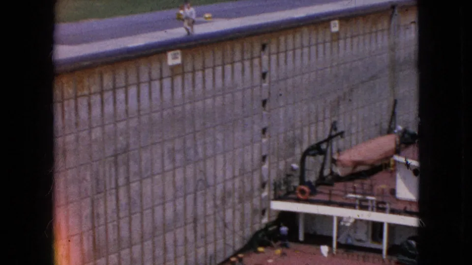 The frame looks down at a concrete lock chamber wall with ship deck structures and equipment partially visible below.