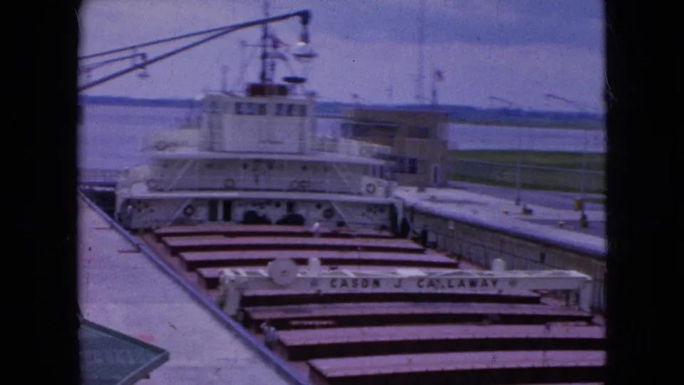 A docked vessel in the canal lock shows deck hatches, bridge structures, railings, water beyond the lock, and the readable name Cason J. Callaway.