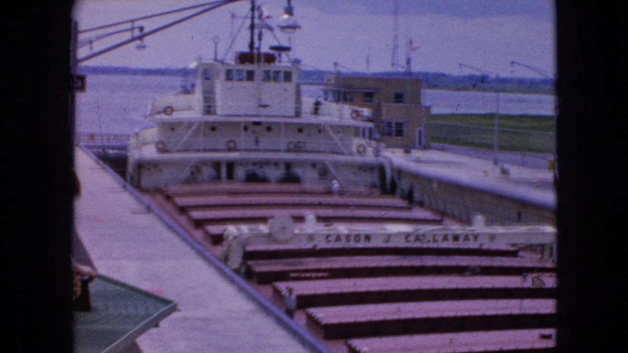 1964 Niagara Falls, New York home-movie frame showing the CASON J. CALLAWAY in a lock, partially divided by a dark window or structural frame at the foreground.
