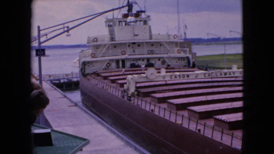 1964 8mm frame near Niagara Falls, New York, showing the freighter Cason J. Callaway from above as it sits in a lock beside dockside structures and water.