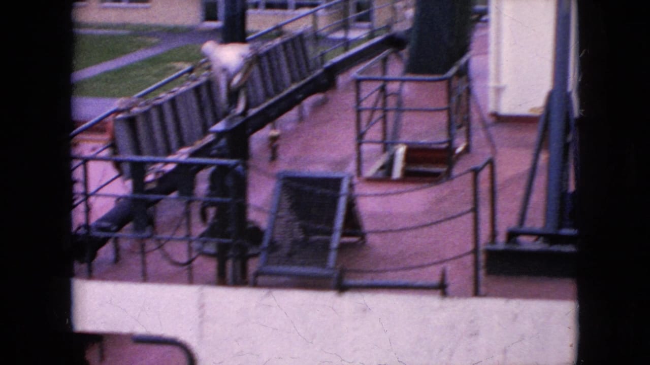 1964 8mm home-movie frame from the Niagara Falls, New York clip showing a large boat deck with railings, deck equipment, and a partly visible seated person near the edge of the frame.