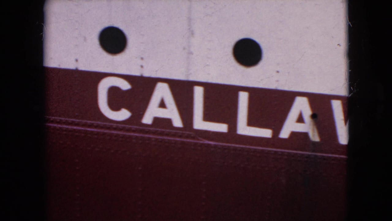 1964 8mm frame from the United States showing a close, cropped view of a red and white vessel side with partial Callaway lettering and dark round portholes.