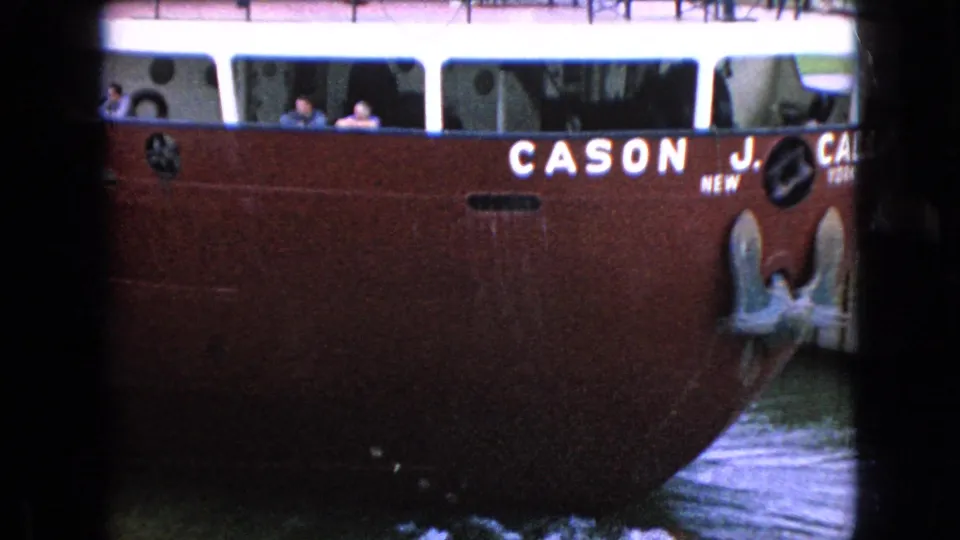 The red CASON J. CALLAWAY is framed from the side near the bow, with white cabin windows, people aboard, painted lettering, and water alongside.