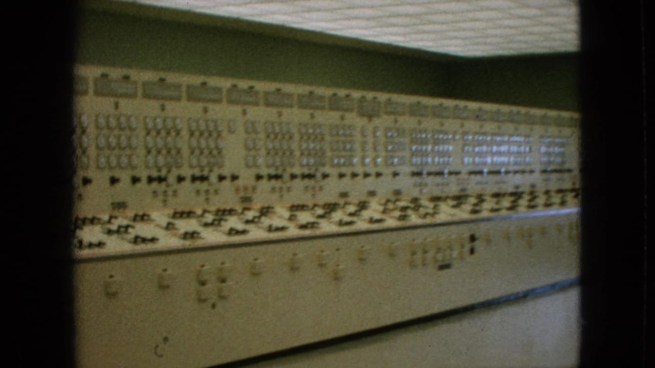 1964 Niagara Falls, New York footage showing a long analog control console with many dials, switches, and indicator panels under a tiled ceiling.