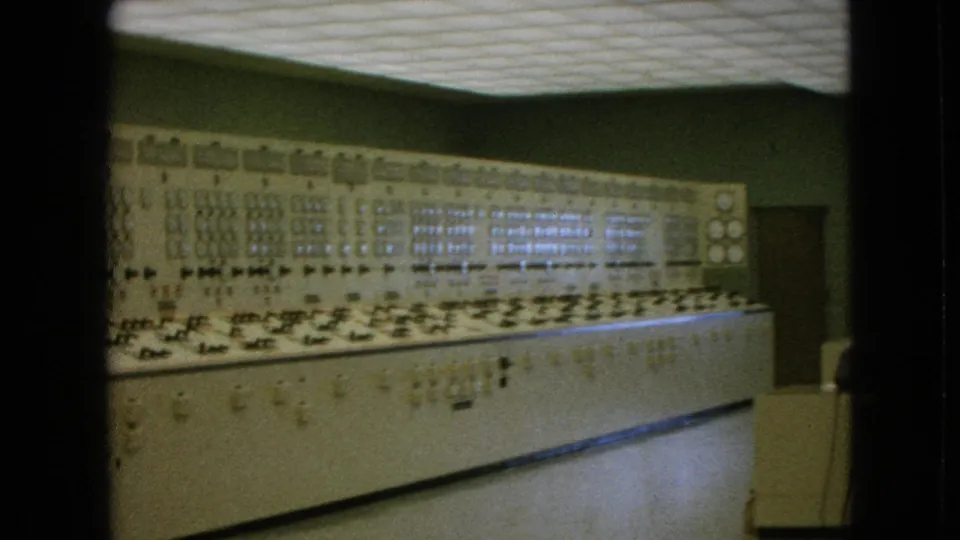 A large 1960s industrial control room in Niagara Falls, New York, with a long console, analog instruments, and open floor space in front.