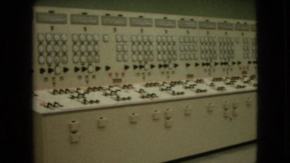 1964 Niagara Falls, New York frame showing a closer section of the computer-era console with clustered gauges, switch banks, indicator lights, and lower cabinet panels.
