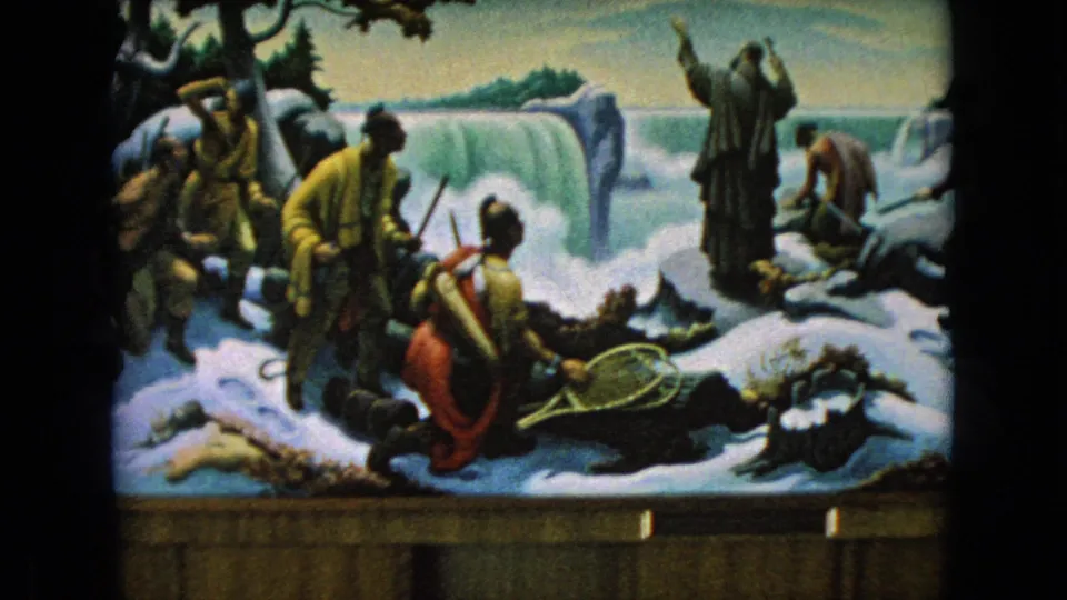 1964 Niagara Falls, New York 8mm frame showing a closer visitor-shot view of a snowbound explorer tableau with figures gathered around a fallen body-like form near a waterfall backdrop.